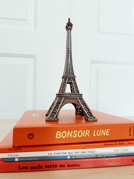 Eiffel Tower statue on stack of French books for kids