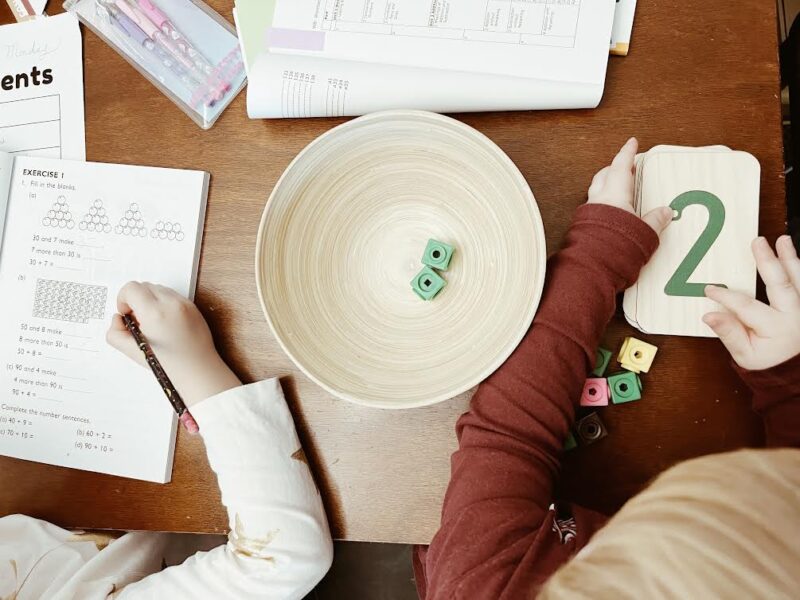overhead picture of two kids working on maths at different levels