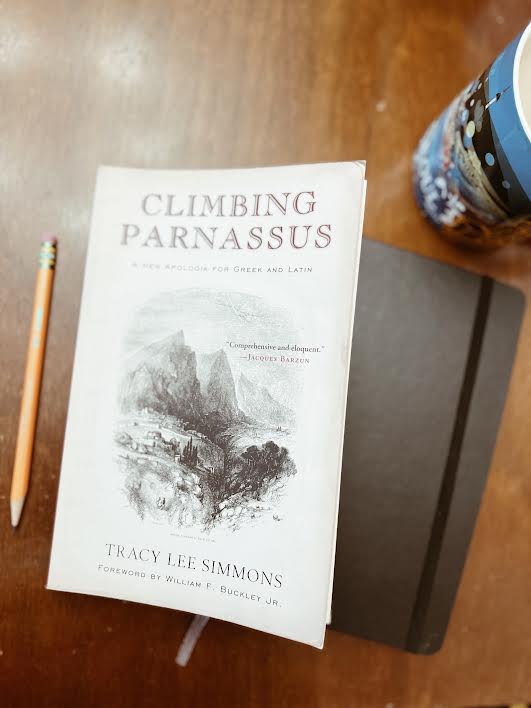 Climbing Parnassus book on table with coffee and notebook