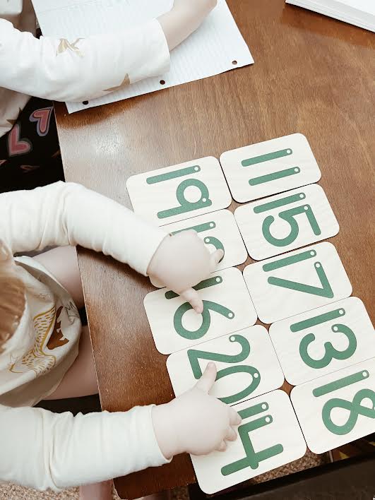 boy using Montessori materials to learn his numbers