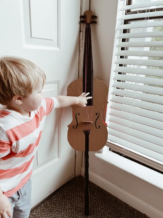 cardboard cello finished, kid trying to touch it