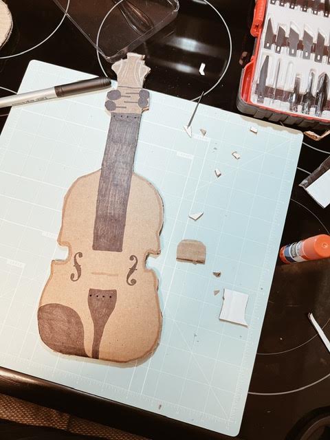 step 2 of diy cardboard viola is colouring in the instrument with a Sharpie